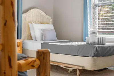 a bedroom with a bed and a chair and a window at Cabin Oasis - Nestled in the Woods Seclusion in Blakeslee