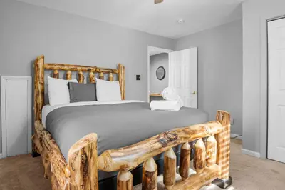 a bedroom with a large bed with a wooden frame at Cabin Oasis - Nestled in the Woods Seclusion in Blakeslee