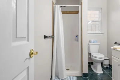 a bathroom with a toilet and a shower door at Cabin Oasis - Nestled in the Woods Seclusion in Blakeslee