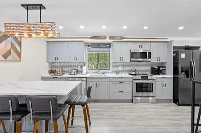 a kitchen with white cabinets and a table with chairs at The Cozy Cubhouse Perfect Couples Getaway in Thornhurst