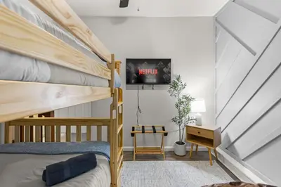 a bedroom with a bunk bed and a tv on a wall at Cabin in the Skye - 5 BDs Lake Harmony in Lake Harmony