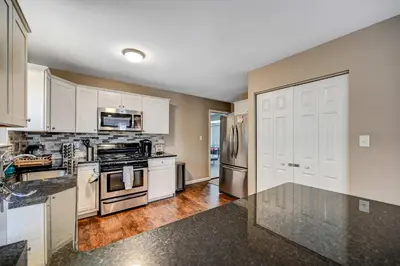 a kitchen with white cabinets and stainless steel appliances at Spacious Retreat - Outdoor Oasis Games and more in Blakeslee