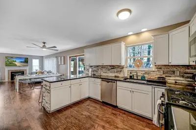 a large kitchen with white cabinets and a table at Spacious Retreat - Outdoor Oasis Games and more in Blakeslee