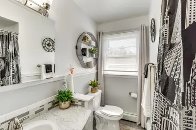 a white bathroom with a toilet and a sink at Peaceful 1-Acre Parksville Home Large Deck and Yard in Parksville