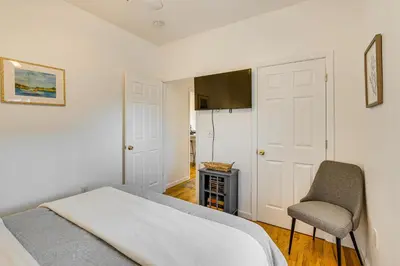a bedroom with a bed and a chair at Walk to Beach Keansburg Home with Patio and Fire Pit! in Keansburg