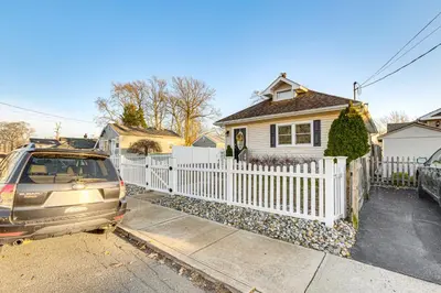 a car parked in front of a white fence at Walk to Beach Keansburg Home with Patio and Fire Pit! in Keansburg