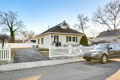 a car parked in front of a house with a white fence at Walk to Beach Keansburg Home with Patio and Fire Pit! in Keansburg