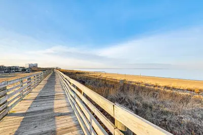 a wooden boardwalk leading to the beach at Walk to Beach Keansburg Home with Patio and Fire Pit! in Keansburg