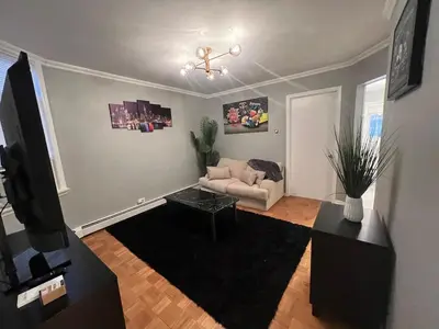 a living room with a couch and a table at Waterfront 4BR apt - 15Min to MetLife and TIMES SQ in Union City