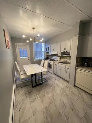 a kitchen with white cabinets and a table at Waterfront 4BR apt - 15Min to MetLife and TIMES SQ in Union City