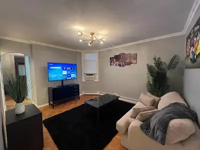 a living room with a couch and a flat screen tv at Waterfront 4BR apt - 15Min to MetLife and TIMES SQ in Union City