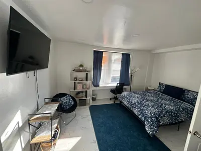 a bedroom with a bed and a flat screen tv at F and R property in Philadelphia