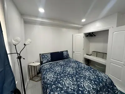 a bedroom with a bed with a blue and white blanket at F and R property in Philadelphia