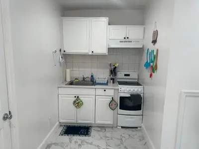 a white kitchen with a sink and a stove at F and R property in Philadelphia