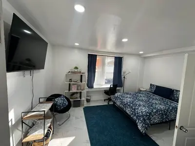 a bedroom with a bed and a flat screen tv at F and R property in Philadelphia