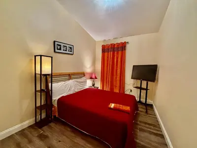 a bedroom with a red bed and a television at MOTEL House in Newark