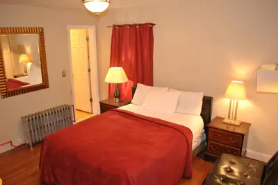 a bedroom with a bed and a mirror and a chair at MOTEL House in Newark
