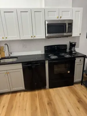 a kitchen with a black stove and a microwave at Cozy Stay Near Fishtown - Close to Subway & Center City by Globenest in Philadelphia