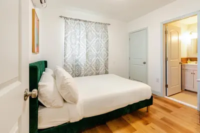 a bedroom with a bed with white sheets and a window at Cozy Stay Near Fishtown - Close to Subway & Center City by Globenest in Philadelphia