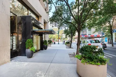 a sidewalk with potted plants in front of a store at UWS 1br w doorman elevator nr Central Park NYC-372 in New York