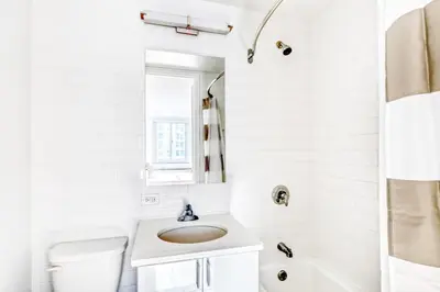 a white bathroom with a sink and a toilet at UWS 1br w doorman elevator nr Central Park NYC-372 in New York