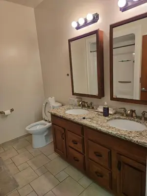 a bathroom with two sinks and a toilet and a mirror at Spooky Nook Bed and Breakfast in Manheim