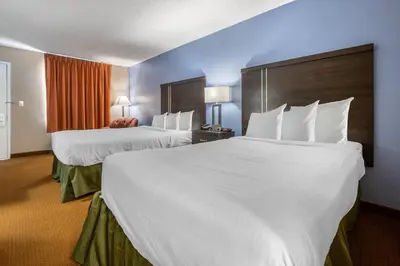 a hotel room with two beds with white sheets at Dutchland Motel in Lancaster