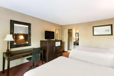 a hotel room with two beds and a desk at Dutchland Motel in Lancaster