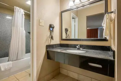 a bathroom with a sink and a mirror and a shower at Dutchland Motel in Lancaster