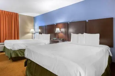 a hotel room with two beds with white sheets at Dutchland Motel in Lancaster