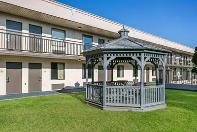 a gazebo in the grass in front of a building at Dutchland Motel in Lancaster