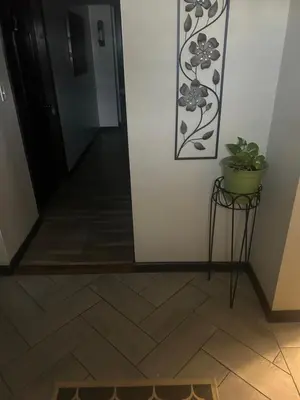 a hallway with a plant on a stand next to a door at Hidden Gem in Middletown