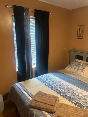 a bedroom with a bed and a window with curtains at Hidden Gem in Middletown