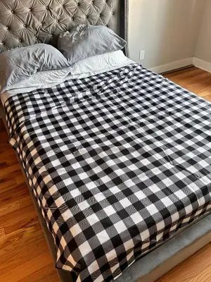 a bed with a black and white checkered blanket at 18stStays in Philadelphia