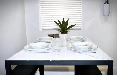 a white table with bowls and plates on it at Cozy Cafe, Walk to The Mall, 30min to NYC & 5min to EWR in Elizabeth