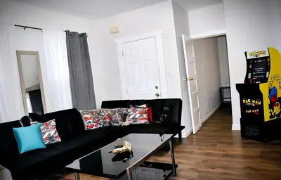 a living room with a black couch and a table at Cozy Cafe, Walk to The Mall, 30min to NYC & 5min to EWR in Elizabeth