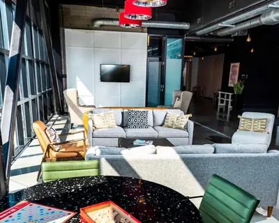 a living room with couches and a table and a tv at Hotel Nyack, a JdV by Hyatt Hotel in Nyack