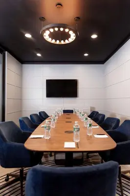 a conference room with a large wooden table and blue chairs at Hotel Nyack, a JdV by Hyatt Hotel in Nyack