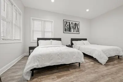 two beds in a bedroom with white walls at Spacious 3-Bedroom Apartment near NYC - 15min to Times Square, Empire State Building, Central Park, Statue of Liberty in Jersey City