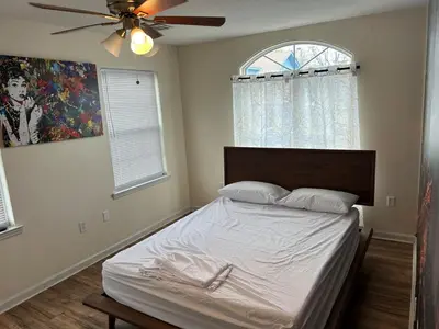 a bedroom with a bed with a ceiling fan at Luxury Townhouse in Newark in Newark