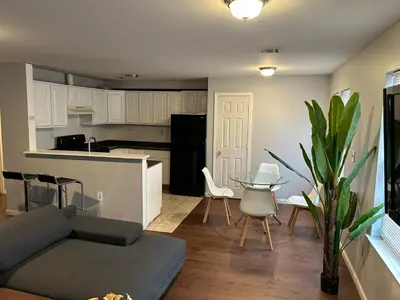 a living room with a couch and a table and a kitchen at Luxury Townhouse in Newark in Newark