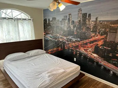 a bedroom with a large painting of a city at Luxury Townhouse in Newark in Newark