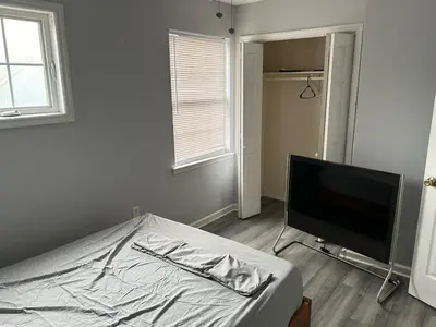 a bedroom with a bed and a flat screen tv at Luxury Townhouse in Newark in Newark