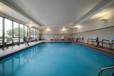 a pool in a hotel with chairs and tables at Fairfield by Marriott Inn & Suites Lancaster in Lancaster