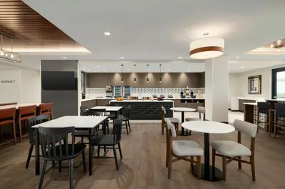 a restaurant with tables and chairs and a bar at Fairfield by Marriott Inn & Suites Lancaster in Lancaster