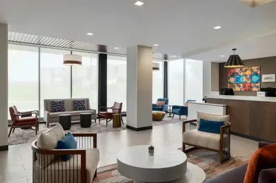 a lobby with chairs and tables in a building at Fairfield by Marriott Inn & Suites Lancaster in Lancaster