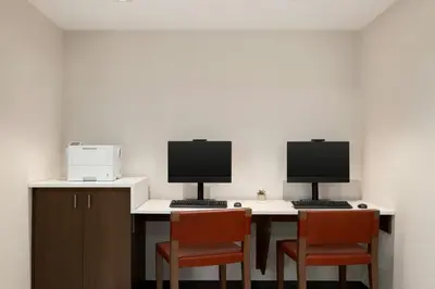 two computer monitors sitting on a desk with chairs at TownePlace Suites by Marriott Lancaster in Lancaster
