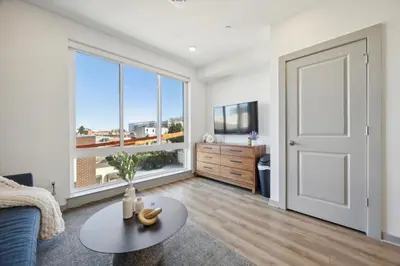 a living room with a couch and a table and a window at The Commons on Ludlow in Philadelphia