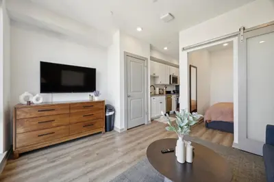 a living room with a flat screen tv on a wooden dresser at The Commons on Ludlow in Philadelphia