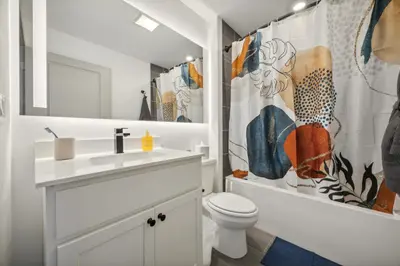a white bathroom with a toilet and a shower curtain at The Commons on Ludlow in Philadelphia